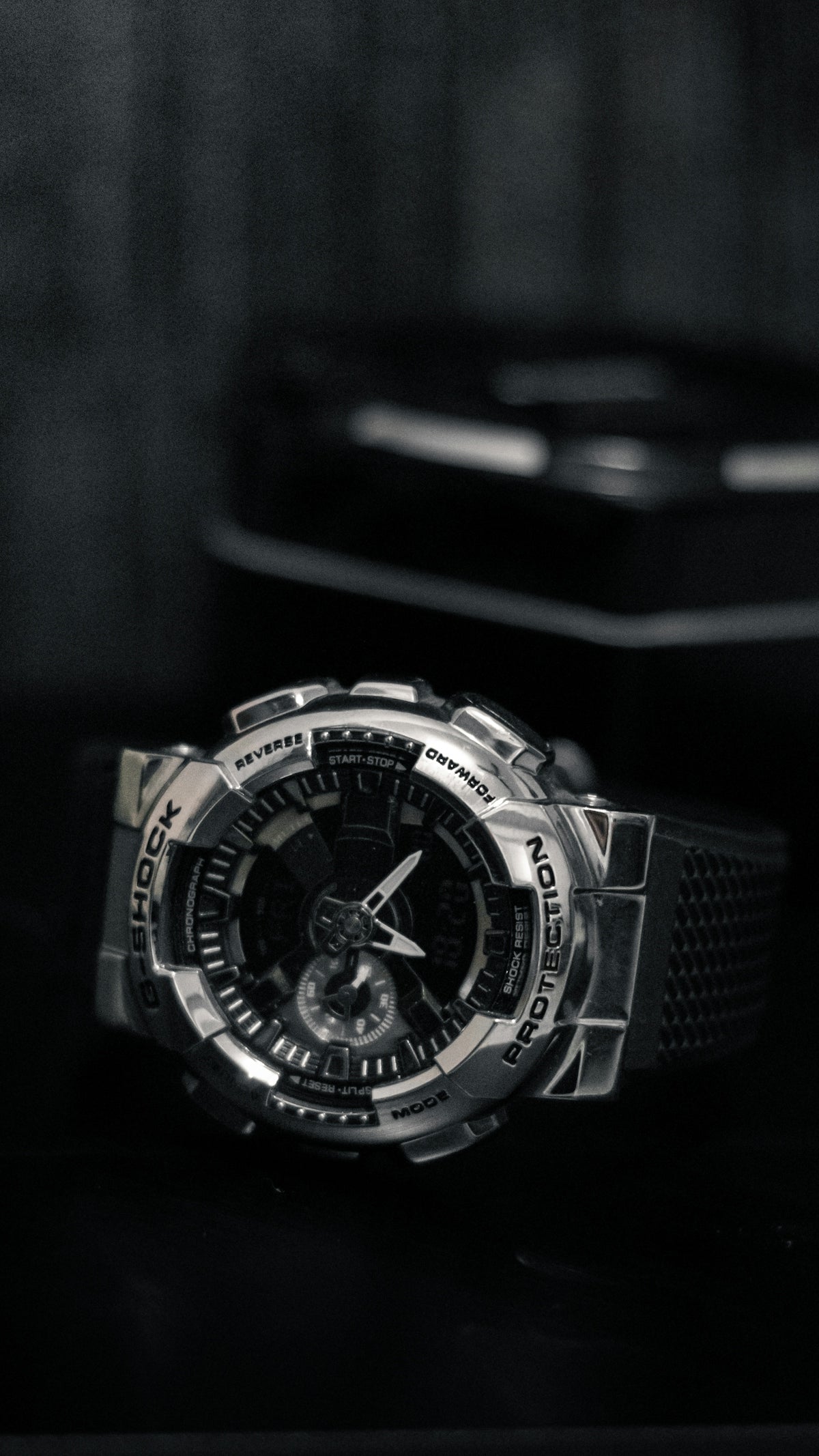 A watch sitting on top of a table next to a cell phone