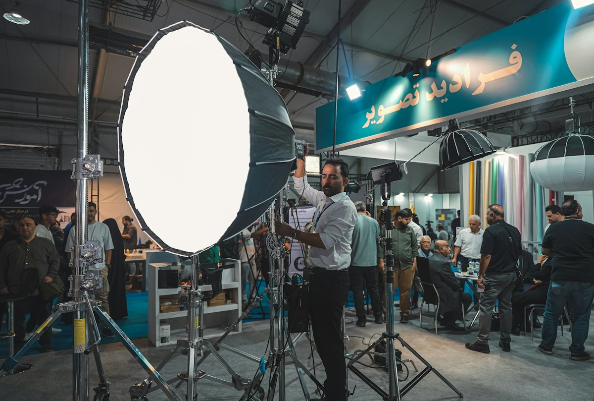 Man adjusting large studio lighting equipment at an event