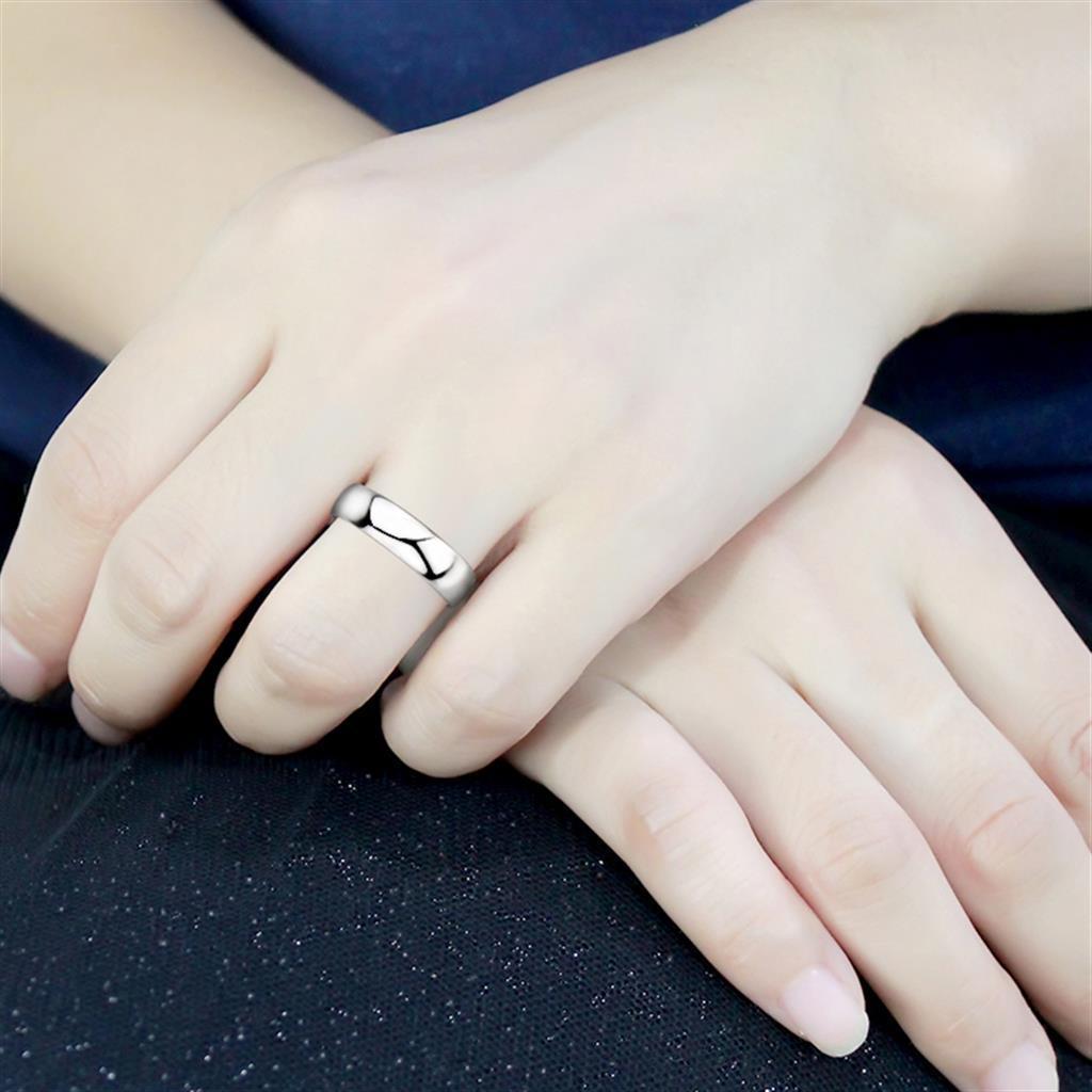 A band style 925 sterling silver ring worn on a finger.