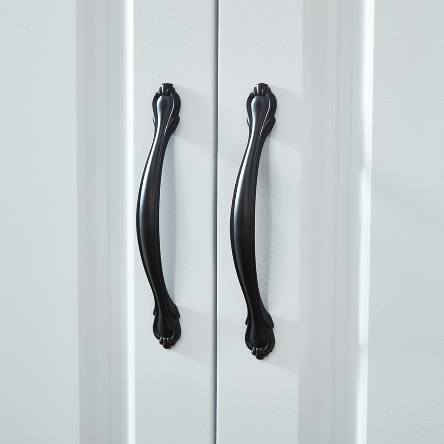 Close-up of Black Door Handles Detail on White Armoire Doors