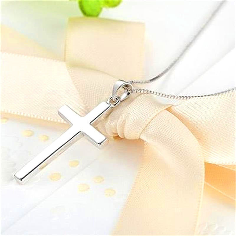 Silver cross necklace on a light fabric background. s925 sterling silver Christian jewelry